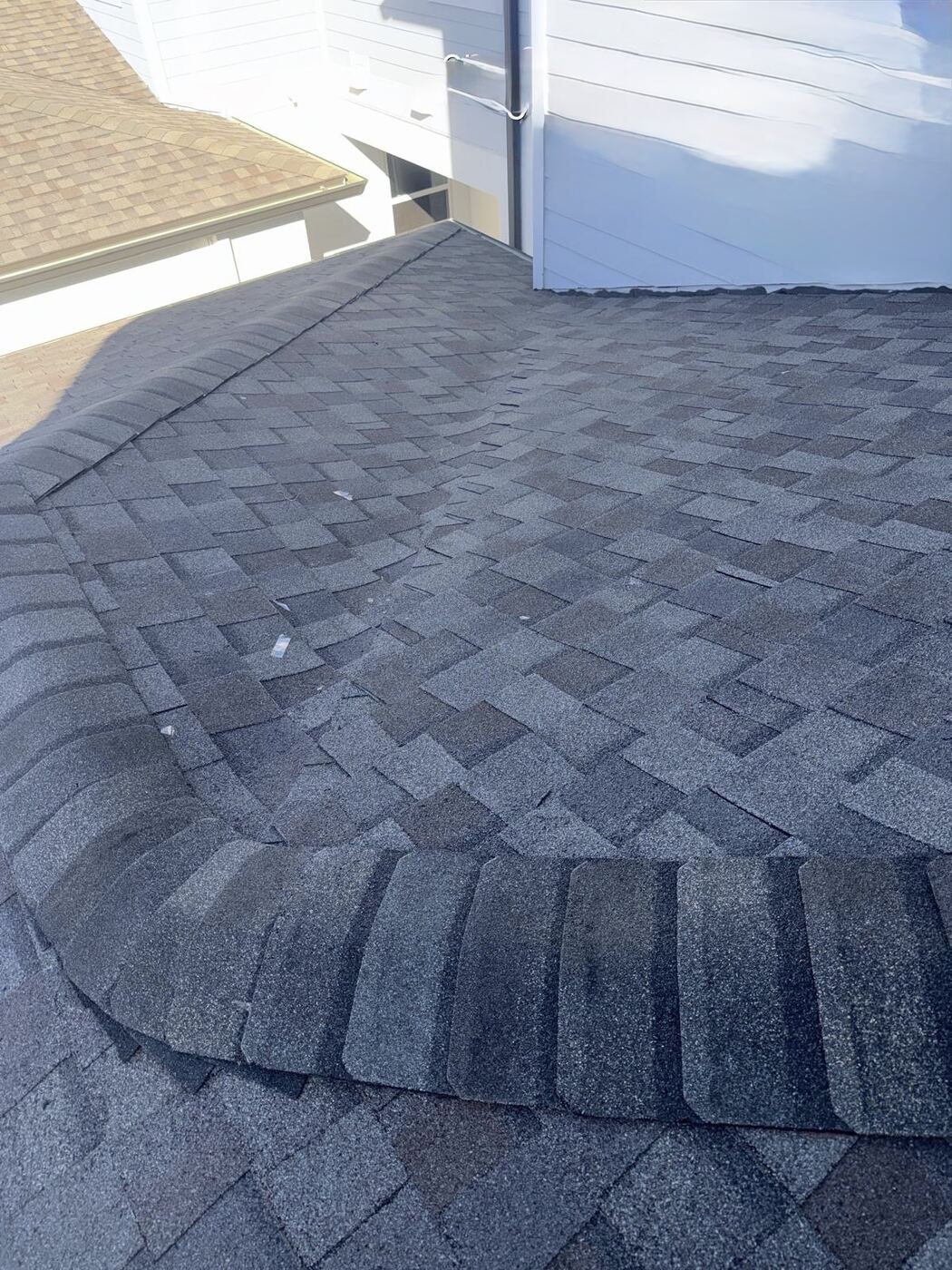 Curling, damaged ridge cap shingles on roof
