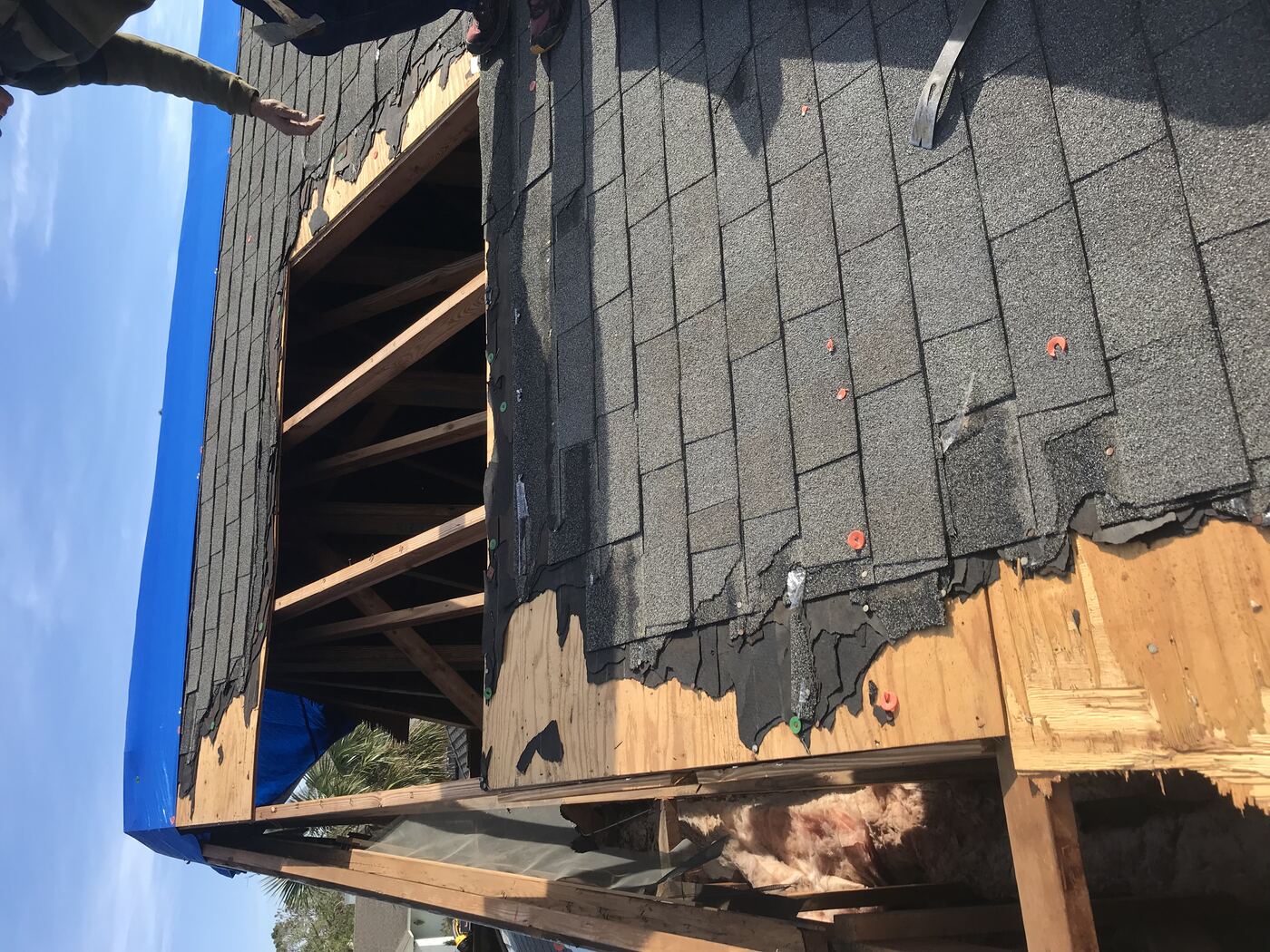 Roof storm damage with exposed rafters